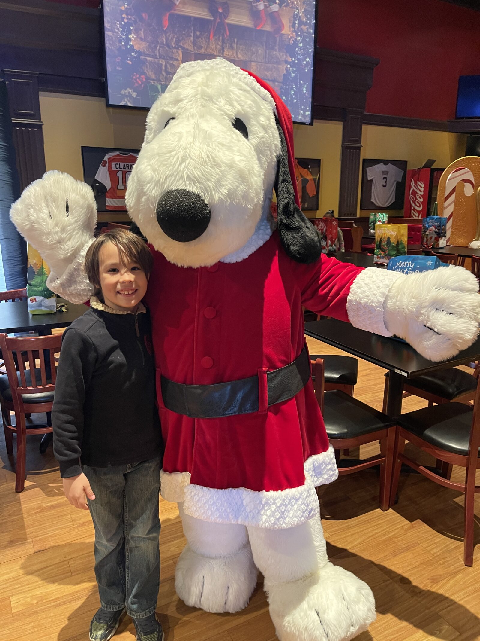 child poses with mascot dorney park holiday event